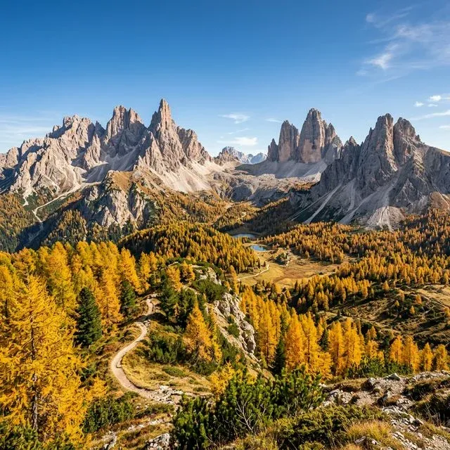 Vista panorâmica das montanhas Dolomitas com os larches amarelos do outono sob um céu azul limpo.